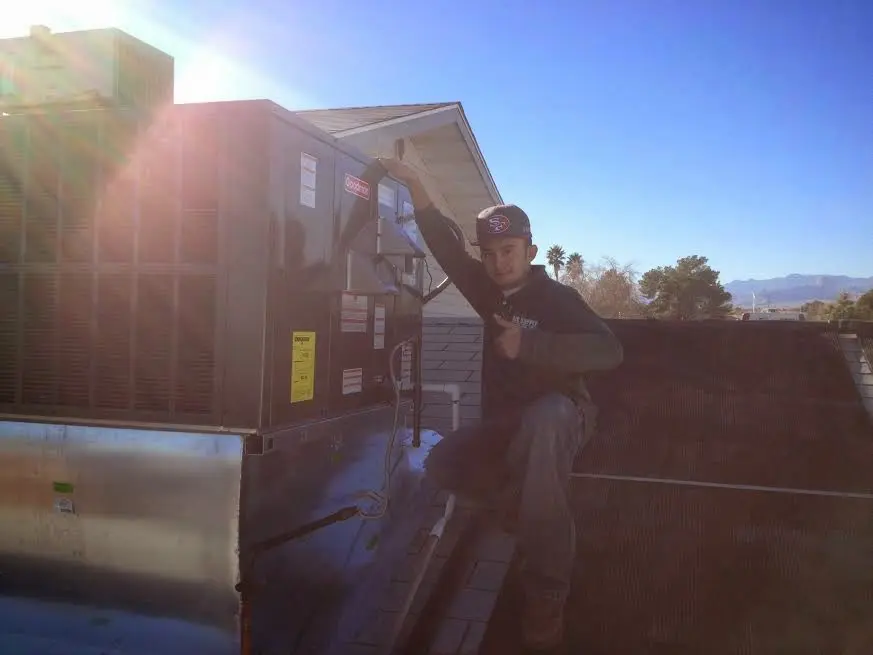 HVAC technician performing AC Tune-Up on a rooftop unit in Sun City Center